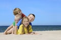 Two girls and two boys in colorful t-shirts playing on a sandy beach Royalty Free Stock Photo