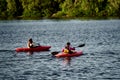 Two girls in a canoe-polo helmet rowing with weights and swimming on water. canupolo. in the rescue yellows. rear view