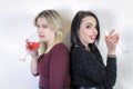 Two girls celebrating an event, and drinking their glasses back to back Royalty Free Stock Photo