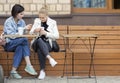 Two girls chat while sitting in a sidewalk cafe