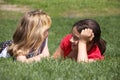 Two girls chatting in grass Royalty Free Stock Photo