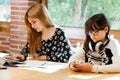 Two girls concentrating with schoolwork.