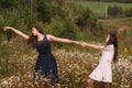 Two girls dancing in field on nature and holding hands Royalty Free Stock Photo