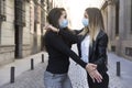 Two girls dancing in the middle of the street. They are wearing a face mask Royalty Free Stock Photo