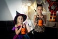 Two girls disguised as a tiger and as a witch are waiting for some candies in All Saints' Day. Royalty Free Stock Photo