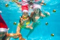 Two girls dive with Christmas tree balls in pool Royalty Free Stock Photo