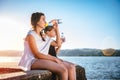 Two girls drinking water and sitting on dock Royalty Free Stock Photo