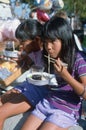 Two girls eating noodles