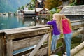 Two girls enjoying the scenic view of Hallstatt lakeside town in the Austrian Alps in beautiful evening light on beautiful day in Royalty Free Stock Photo