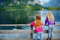 Two girls enjoying the scenic view of Hallstatt lakeside town in the Austrian Alps in beautiful evening light on beautiful day in Royalty Free Stock Photo