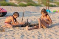 Two girls in the evening on the beach prepare a place for a fire Royalty Free Stock Photo