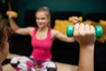 Two girls exercise with dumbbells. Close-up view. Fitness in the living room. Royalty Free Stock Photo