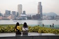 30 4 2021 two girls with face mask sit to chat and enjoy the view of victoria harbour. photo in Tamar Park , Victoria Harbour,