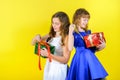 Two girls in festive dresses untie ribbons
