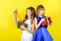 Two girls in festive dresses untie ribbons