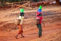 Two girls fetching water with plastic buckets and cans in Burma Myanmar
