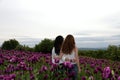 Two girls in a field with purple poppies Royalty Free Stock Photo