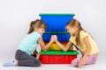 Two girls fight on hands, putting elbows on a box with toys