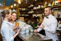 Two girls flirting with barman