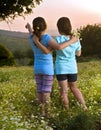 Two girls flowers field at sunset Royalty Free Stock Photo