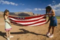 Two girls folding the American flag,