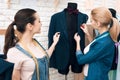Two girls at garment factory desining new man suit jacket. Royalty Free Stock Photo