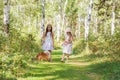 Two girls girlfriend walking in the woods with her beloved pet Spitz