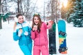 Two girls girlfriends background of snowboards, surprised laughing joke winter park on background of green Christmas