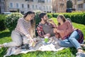 Two girls and a guy eating sandwiches on a picnic Royalty Free Stock Photo