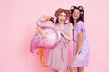 Two girls with hair curlers and pink flamingo baloon. They are celebrating women`s day March 8. Royalty Free Stock Photo