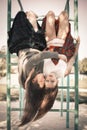 Two girls hang on a horizontal bar in an embrace. The concept of difficult teenagers, bad students.