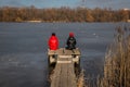 Two girls have a rest on a pier on the river bank Royalty Free Stock Photo