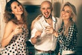 two girls having fun with a guy at a party with a glass of martini Royalty Free Stock Photo