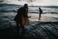 Friends enjoying a playful moment by the lake at sunset during springtime Royalty Free Stock Photo