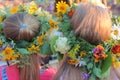 Two girls` heads in crowns of wildflowers, closeup, back view. Ukrainian flower wreath for Ivana Kupala at Midsummer Fest
