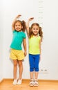 Two girls hold hands over hand near scale on wall Royalty Free Stock Photo