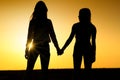 Two girls holding each other hands. Ladies couple on the beach.