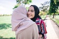 Two girls hug on the sidewalk. Feel joyfull and happy together.