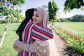 Two girls hug on the sidewalk. Feel joyfull and happy together.