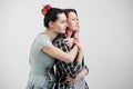 Two girls hug on a white background. Homosexual lesbian couple. Casual clothes.