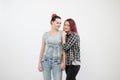 Two girls hug on a white background. Homosexual lesbian couple. Casual clothes.