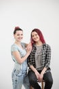 Two girls hug on a white background. Homosexual lesbian couple. Casual clothes.