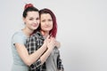 Two girls hug on a white background. Homosexual lesbian couple. Casual clothes.