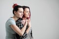 Two girls hug on a white background. Homosexual lesbian couple. Casual clothes.