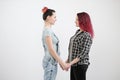 Two girls hug on a white background. Homosexual lesbian couple. Casual clothes.