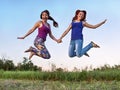 Two girls jumping in the air holding hands Royalty Free Stock Photo