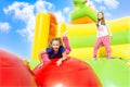 Two Girls Jumping on Inflate Castle Cloudscape Royalty Free Stock Photo