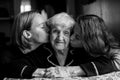 Two girls kiss their grandmother. Love. Black and white portrait Royalty Free Stock Photo