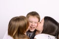 Two girls kissing little laughing boy Royalty Free Stock Photo