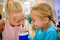 Two girls laughing and drinking a cocktail in a cafe Royalty Free Stock Photo